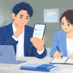 スマートフォンの口コミ評価を落ち着いて確認する社長と、返信の下書きをメモする担当者