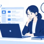 事務所の机のパソコンで問い合わせメールを確認し、壁の時計が見える様子